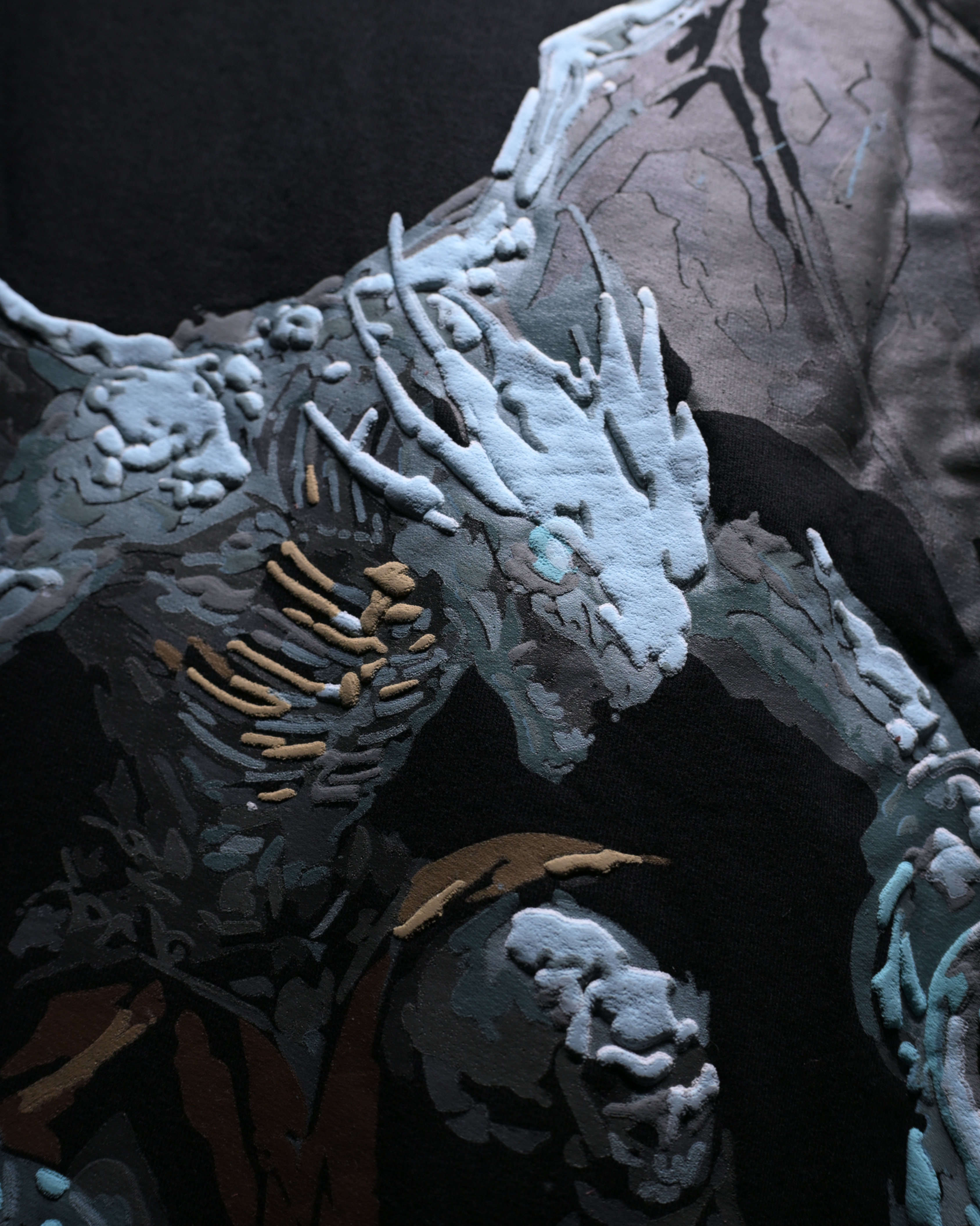 A close-up of a fantasy creature or dragon-like character rendered in a painterly, textured style. The figure has icy blue-gray skin, sharp horns, and dark shadowed areas, with a large stone or rock form in the background.